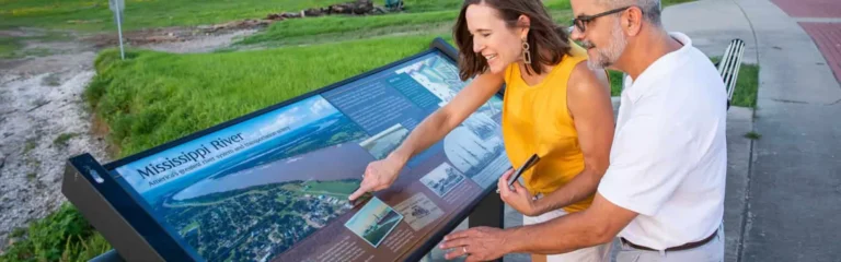a couple reading an interpretive sign on the portal to the past trail in Donaldsonville, LA